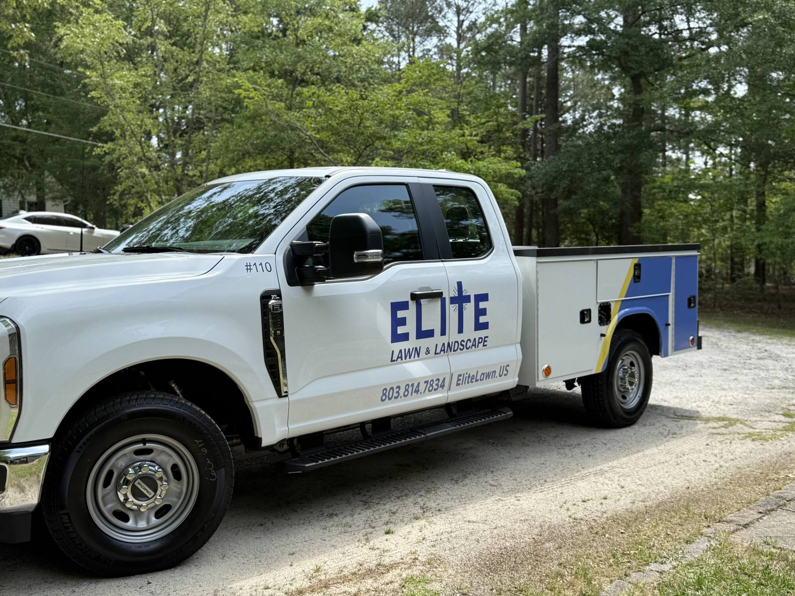 Elite Lawn & Landscape white service truck parked
