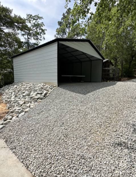 Gravel driveway with metal carport